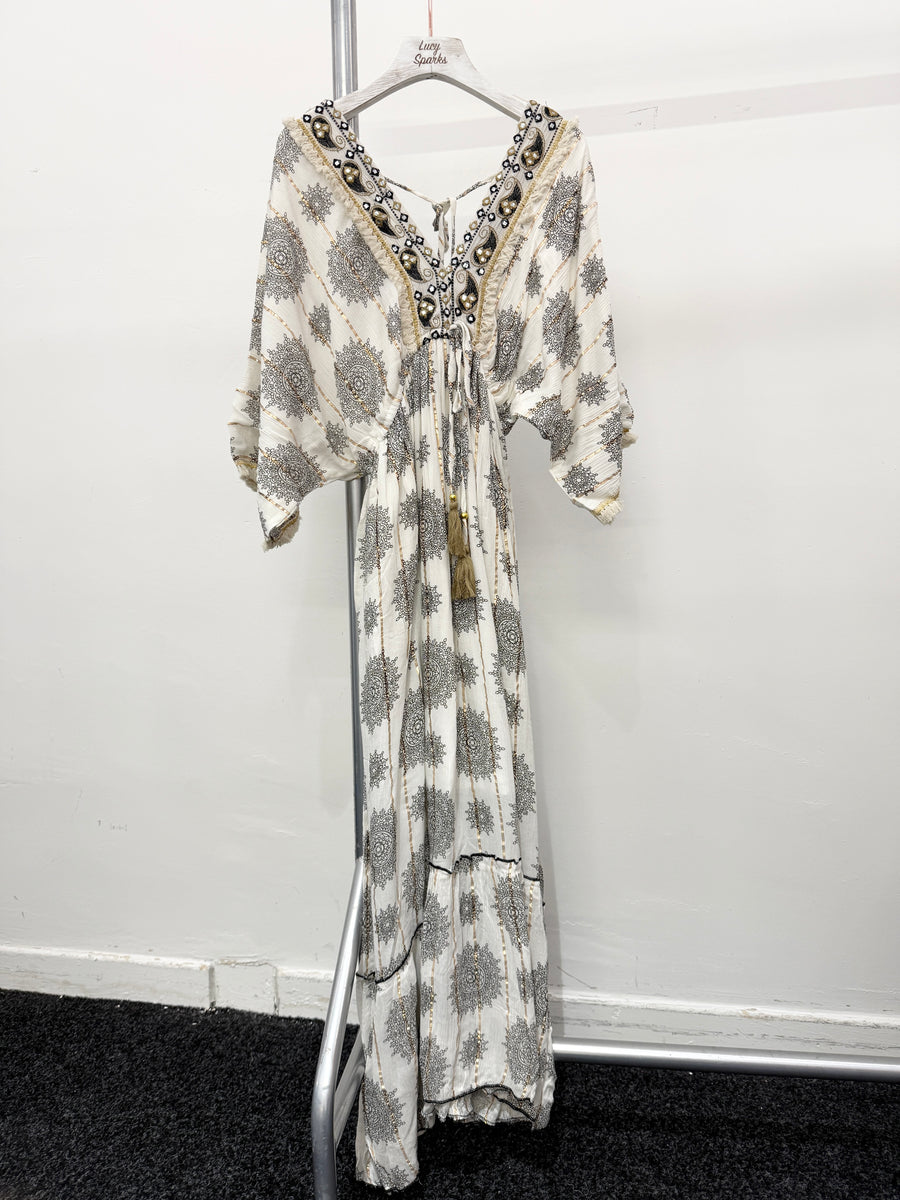 PRINTED MAXI DRESS WITH FLARED SKIRT AND LOOSE FIT TOP. DEEP V NECK FRONT AND BACK AND EMBELLISHED NECKLINE