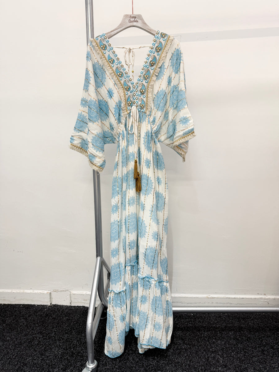 PRINTED MAXI DRESS WITH FLARED SKIRT AND LOOSE FIT TOP. DEEP V NECK FRONT AND BACK AND EMBELLISHED NECKLINE