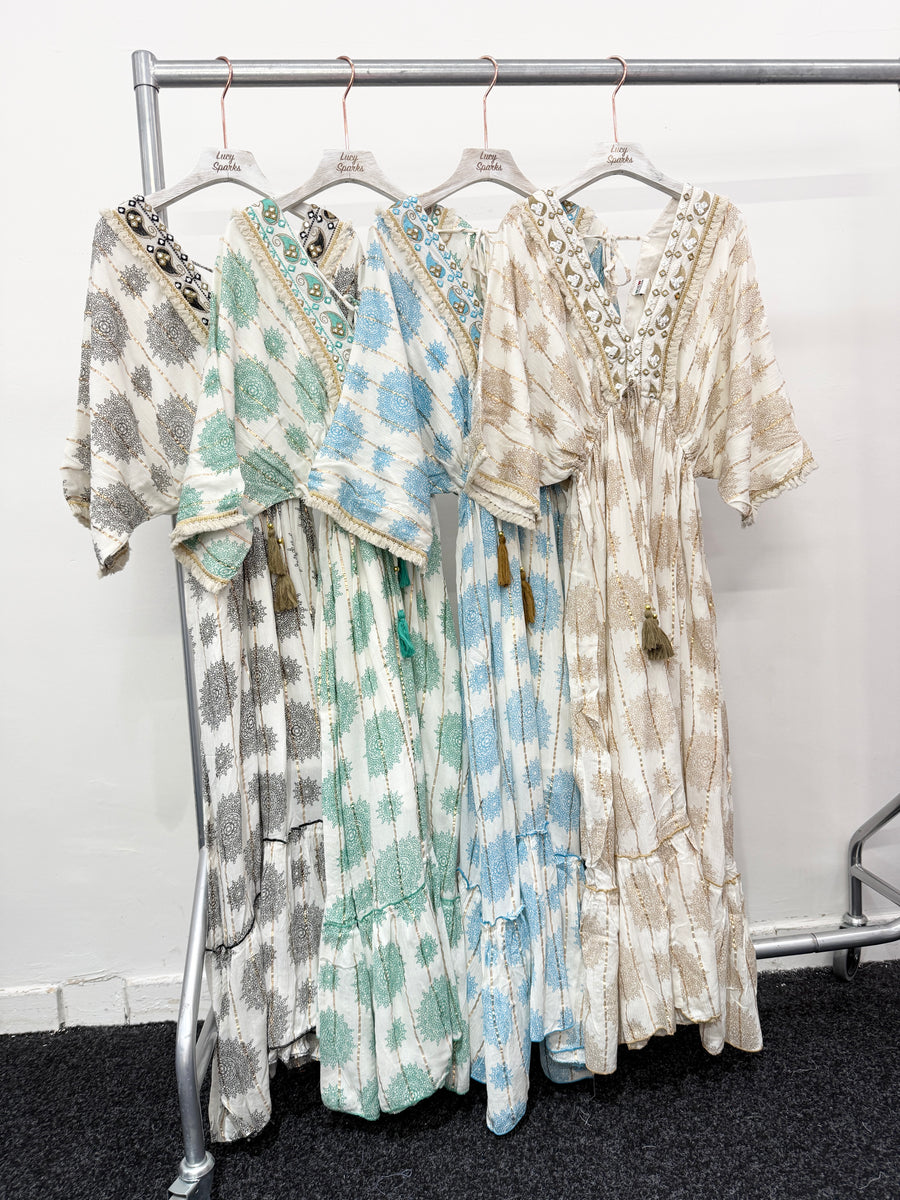 PRINTED MAXI DRESS WITH FLARED SKIRT AND LOOSE FIT TOP. DEEP V NECK FRONT AND BACK AND EMBELLISHED NECKLINE